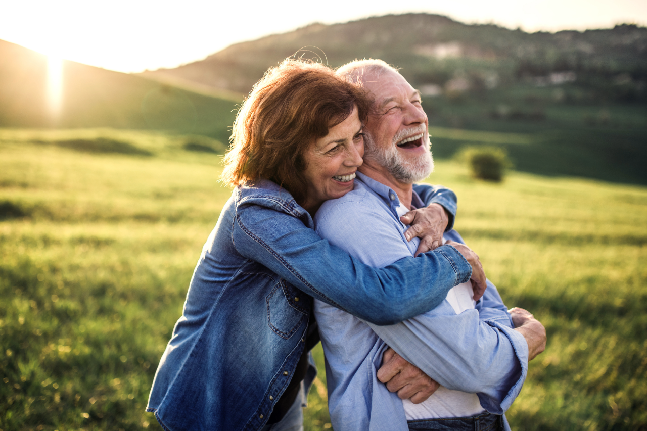 Happy couple smiling after their full arch implant treatment