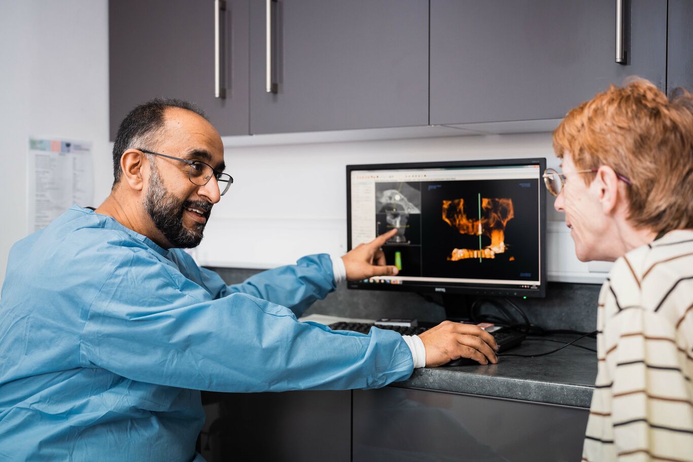 Dentist reviewing 3D scan with a patient during consultation